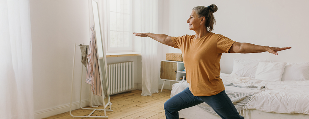 Image of senior woman with eyes closed doing a standing yoga pose